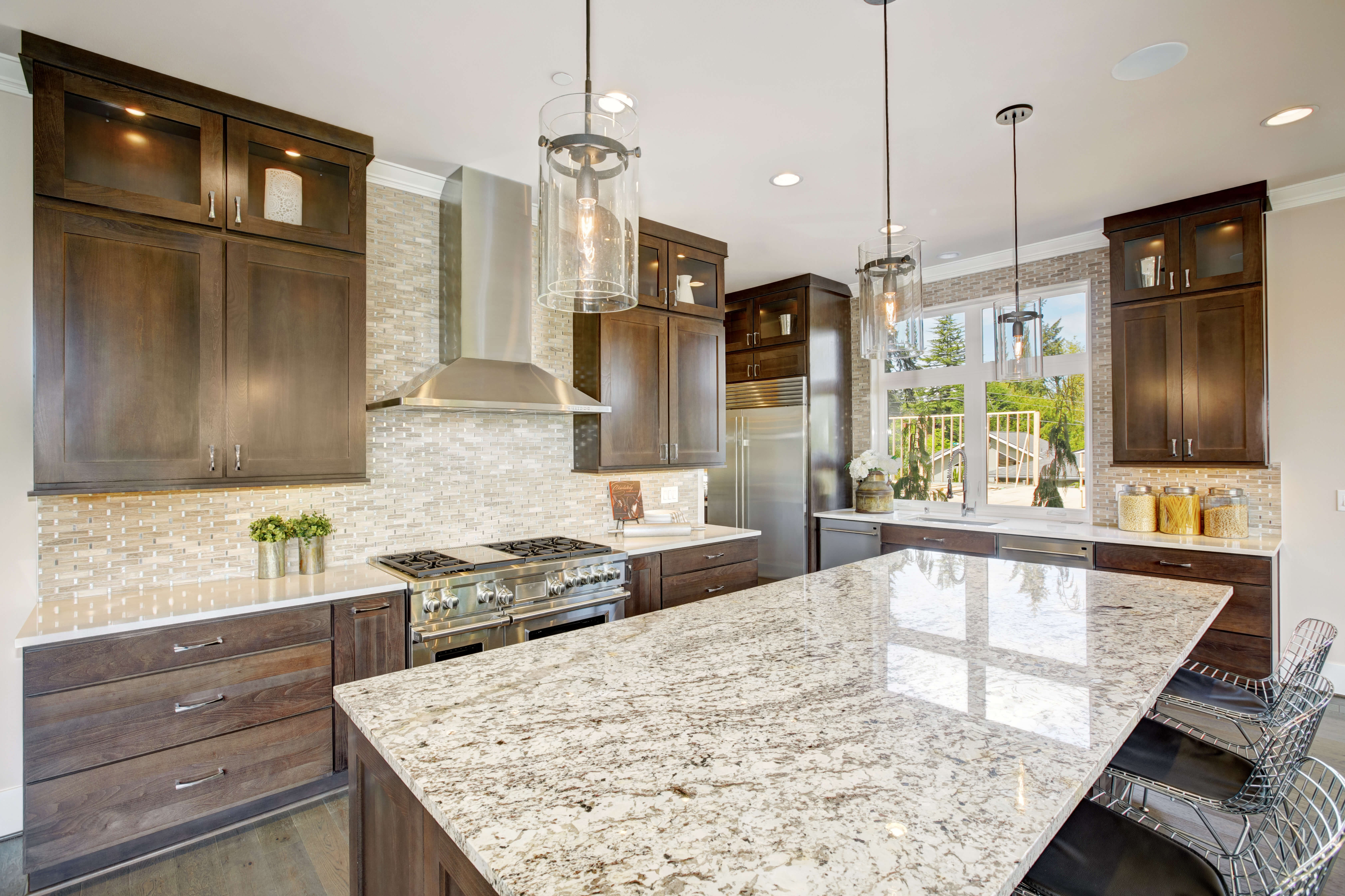 Kitchen with a large island topped in white, gray and brown speckled stone